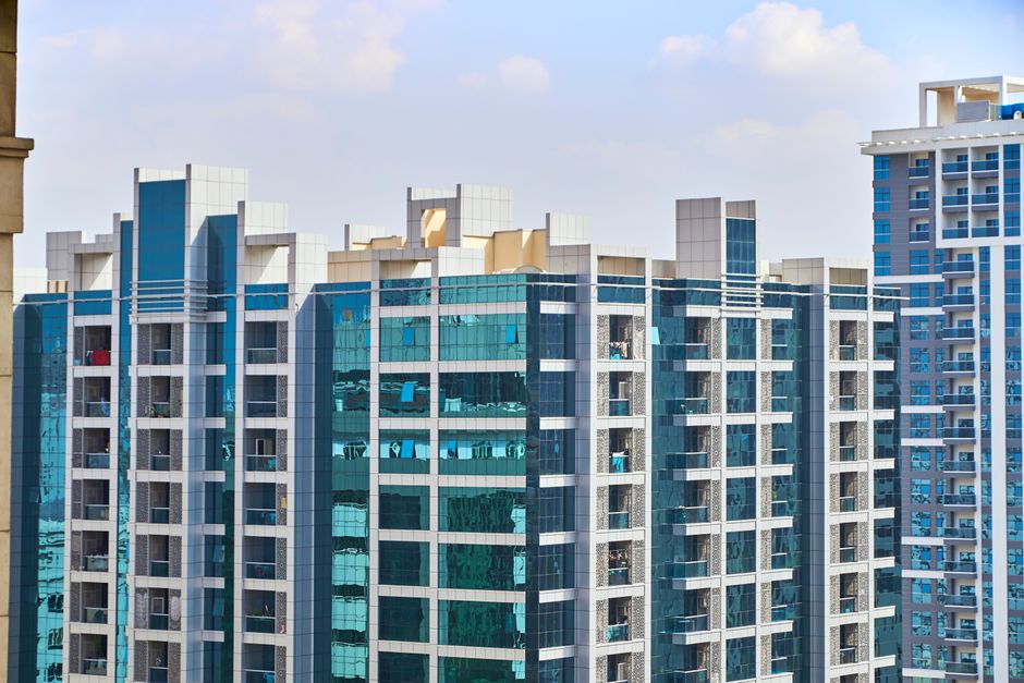 Cityscape view of modern high-rise buildings with reflective glass facades under a blue sky
